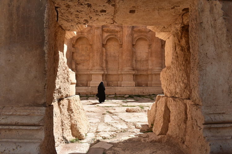 Rear view of woman wearing hijab walking in old building