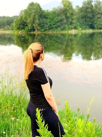 Side view of woman standing by lake