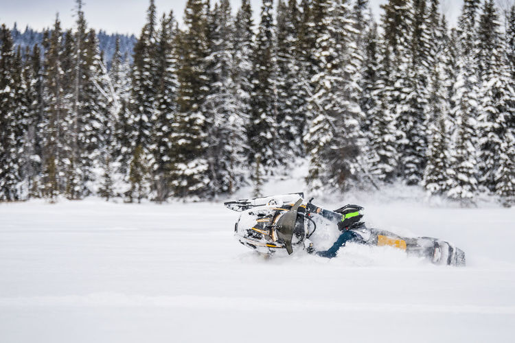 Experienced rider snowmobiling aggressively through deep snow.
