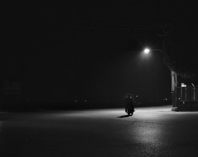 Silhouette man on road at night