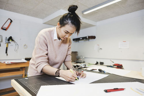 Businesswoman planning on paper at table in creative office