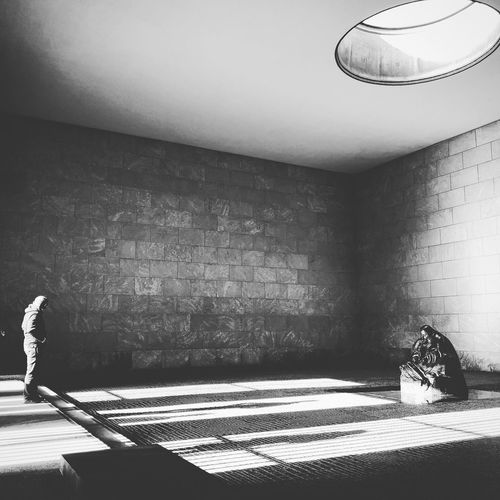 Shadow of man walking on illuminated wall in building