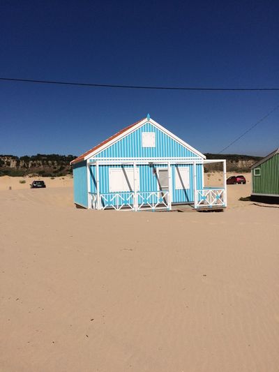 Lifeguard hut at beach against clear blue sky