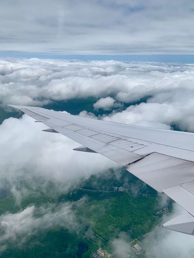 Aerial view of aircraft wing against cloudy sky
