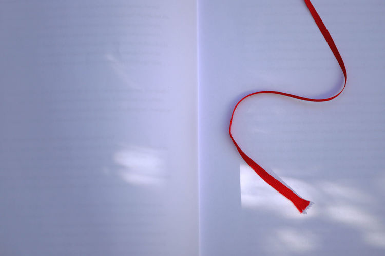 Close-up of heart shape on book against wall