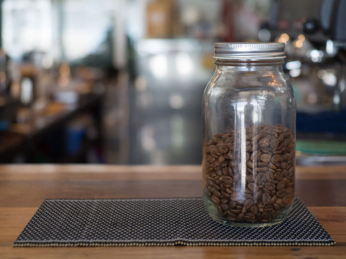 Close-up of coffee beans in jar on table