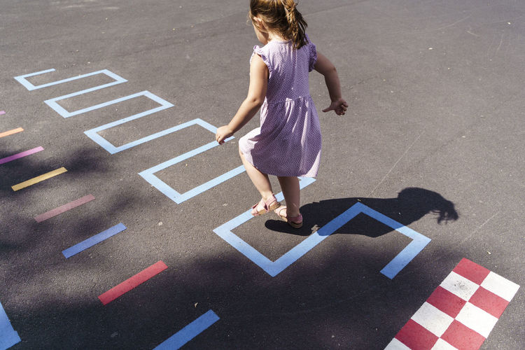 Girl playing hopscotch at playground