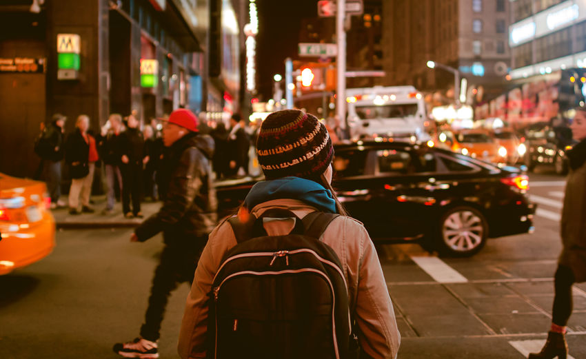 Rear view of woman on city street at night