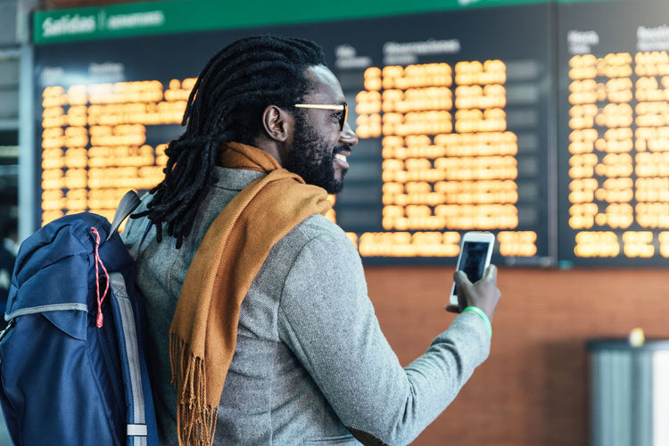 Rear view of businessman using phone at airport