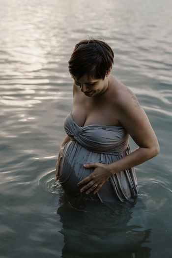 Pregnant woman standing in lake