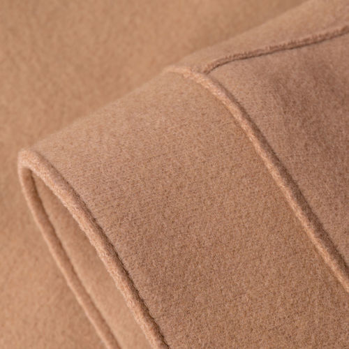 Sleeve of beige woolen coat close up background