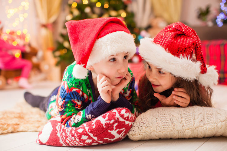 Cute siblings lying on pillow during christmas at home