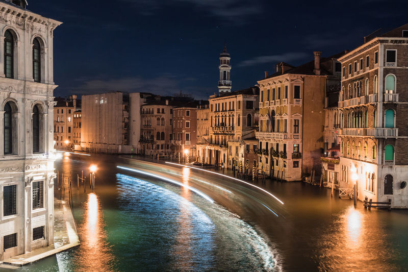 Canal passing through city buildings at night