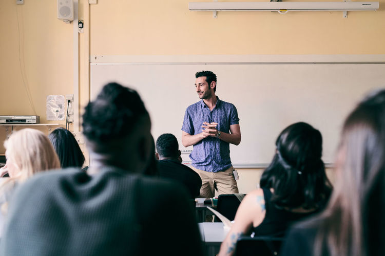 Male teacher teaching multi-ethnic students in classroom