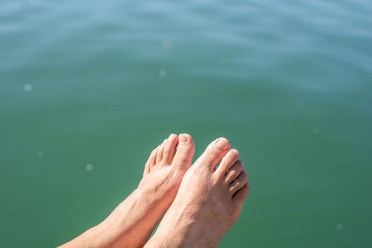 Low section of person relaxing in sea