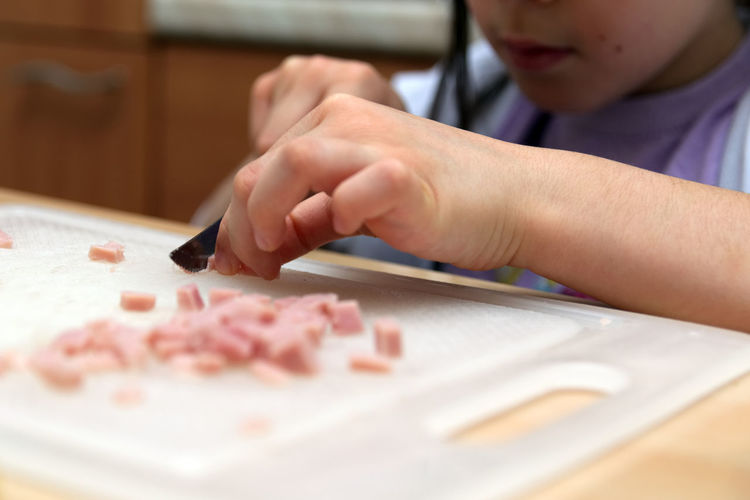 Midsection of boy preparing food on table