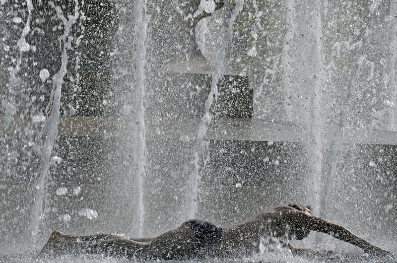 Shirtless man enjoying in fountain at place de la republique