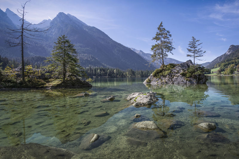 Scenic view of lake by mountains against sky