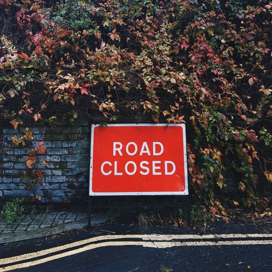 Road sign against wall