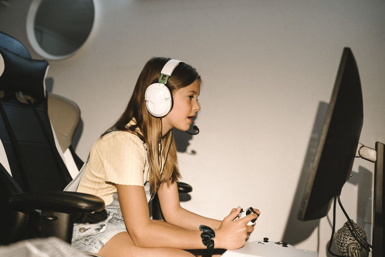 Caucasian girl playing video game on television at home