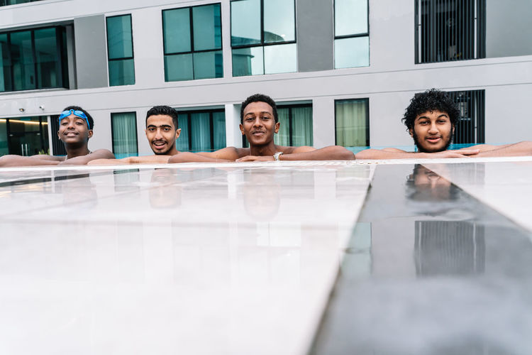 Group of young people leaning on the edge of a pool