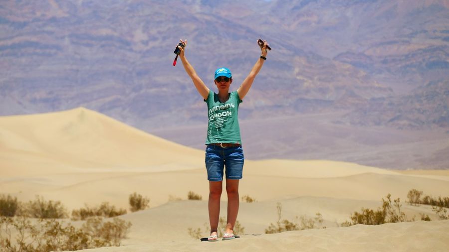 Arms raised young woman standing at death valley