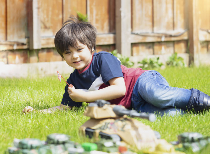 Boy lying on grass at yard