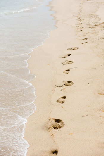 Footprints in the sand along an isolated beach