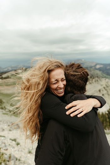 Over the moon female hugs her fiance after a surprise proposal