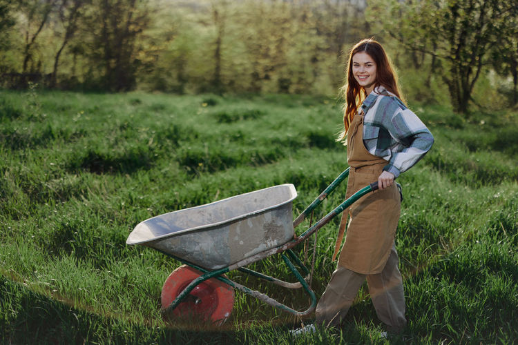 Portrait of young woman standing on field