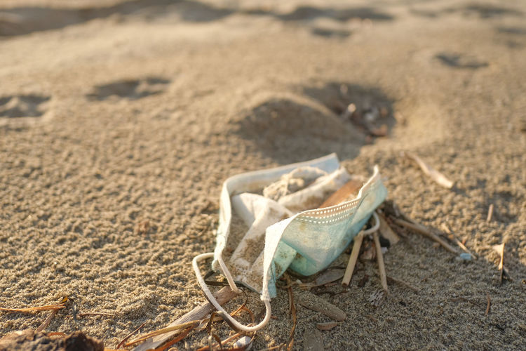 Dirty used surgical face mask discarded on sea coast ecosystem,covid19 pandemic disease pollution 