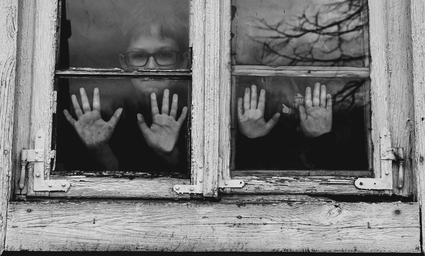 Portrait of boys looking through window