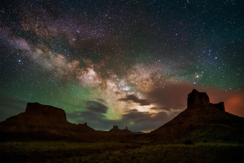 View of mountain against night sky filled with stars and airglow