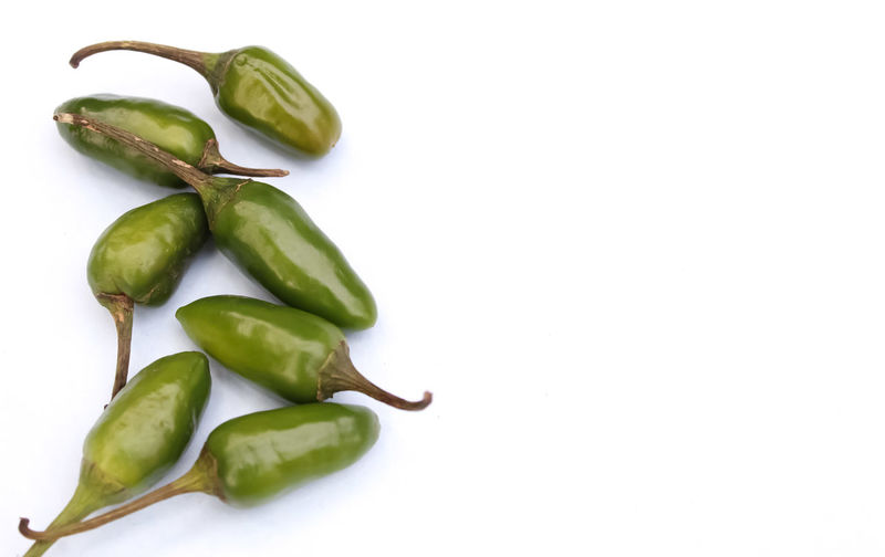 Close-up of green chili pepper against white background