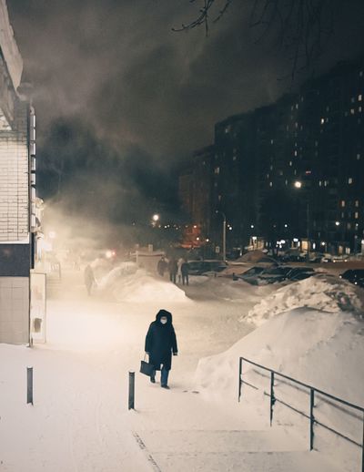 Woman walking in a snowstorm in the night city