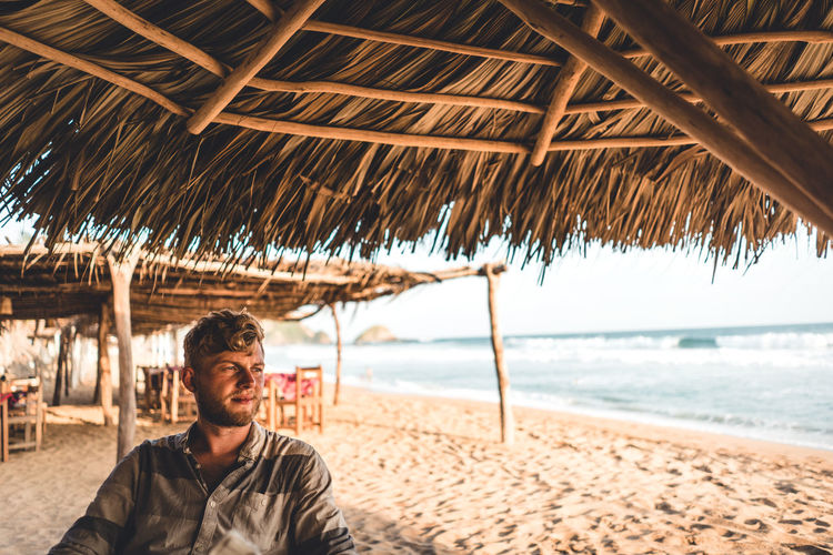 Thoughtful young man sitting on beach