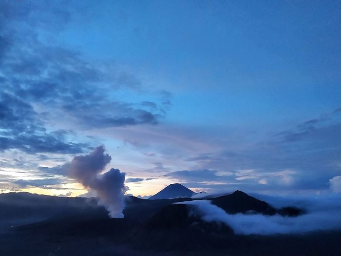 Scenic view of volcanic mountain against sky during sunset