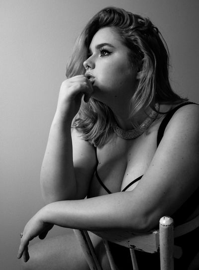 Thoughtful seductive woman looking away against wall