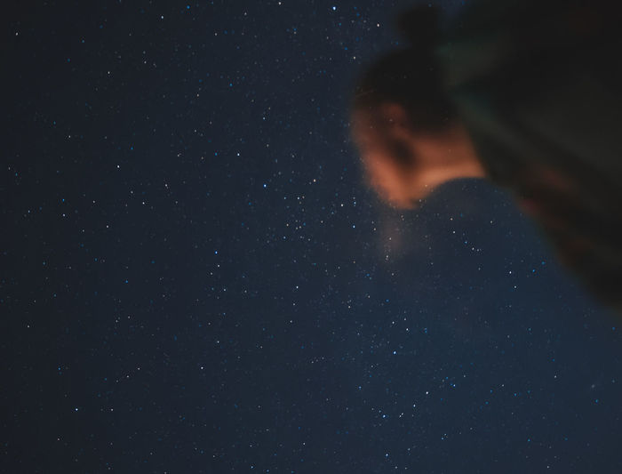 Young woman watching the night sky, stars and milky way, selective focus