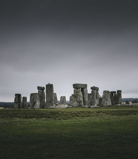 Stonehenge on field against sky