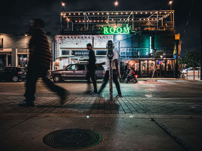 People on sidewalk in city at night