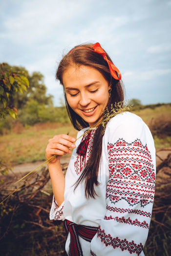 Photo of a smiling young woman in ethnic ukrainian shirt