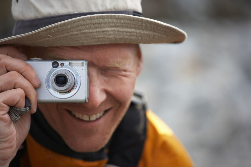 Man taking picture with digital point and shoot camera in greenland