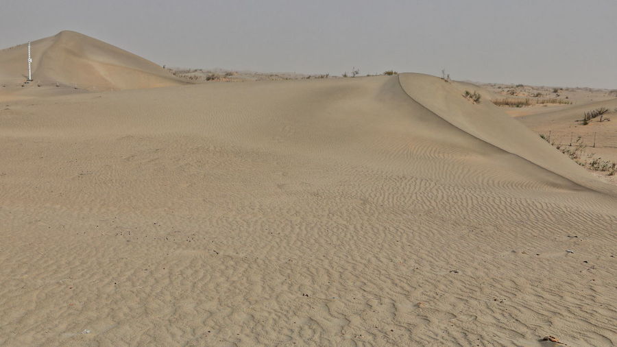 Sand dunes in desert against sky
