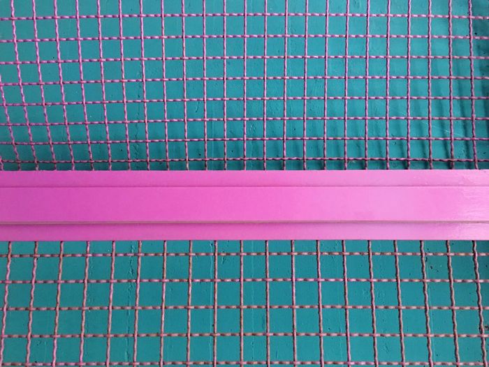 Full frame shot of metal grate against blue wall