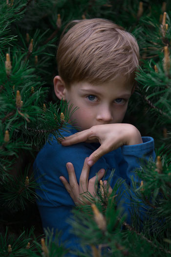 Close-up of boy on grass against trees