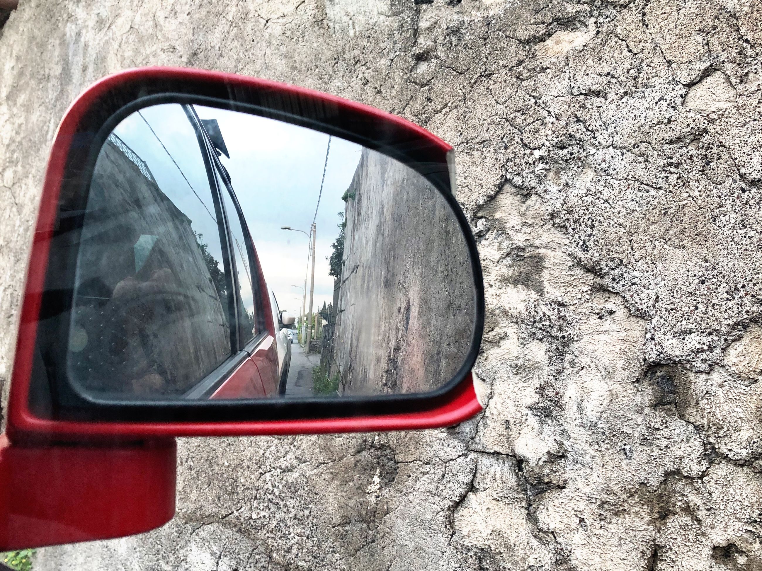 reflection, land vehicle, side-view mirror, mirror, mode of transportation, transportation, motor vehicle, car, day, road, close-up, glass - material, no people, outdoors, nature, travel, city, street, red, rear-view mirror, vehicle mirror