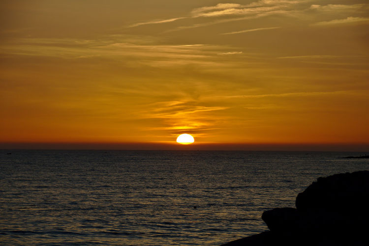 Scenic view of sea against romantic sky at sunset