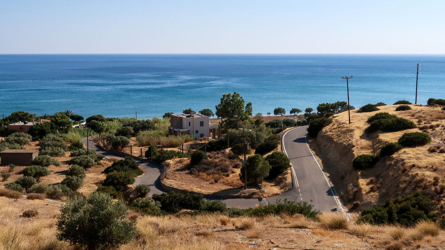 Bending road through the lands with olive trees and libyan sea further away - crete