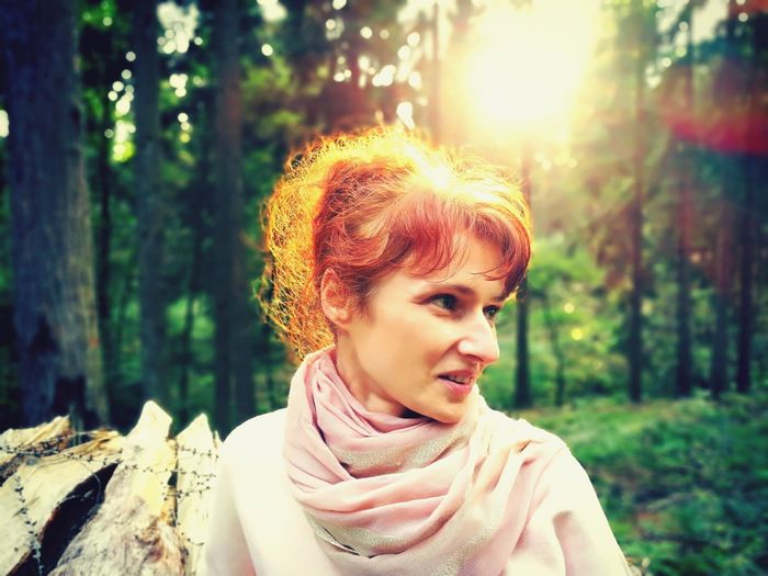Portrait of young woman looking away in forest